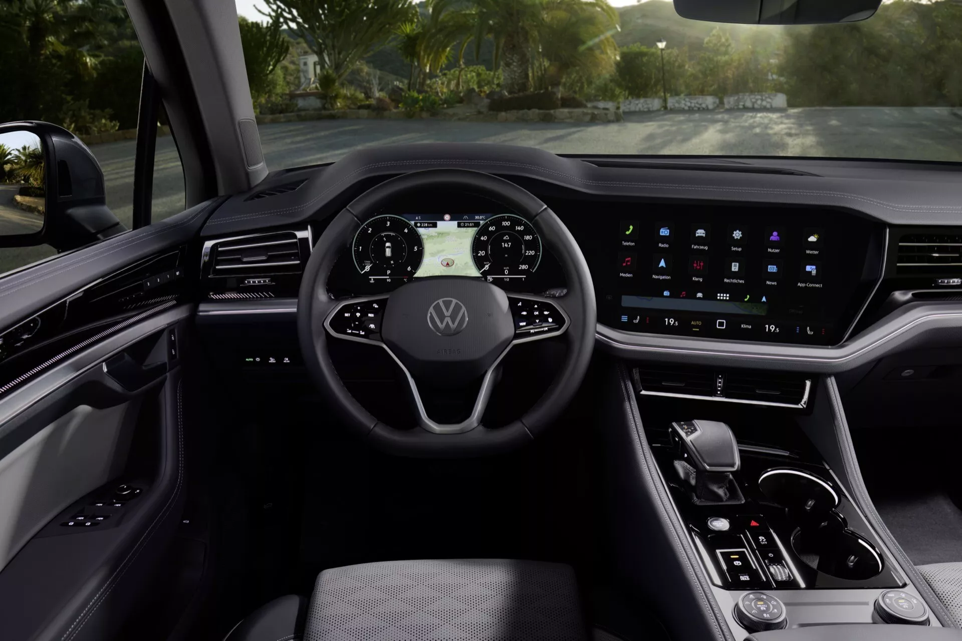 Wnętrze Volkswagena Touarega 2023 przedstawiające cyfrowy zegar, wielofunkcyjną kierownicę i zaawansowany system infotainment z ekranem dotykowym z perspektywy kierowcy
