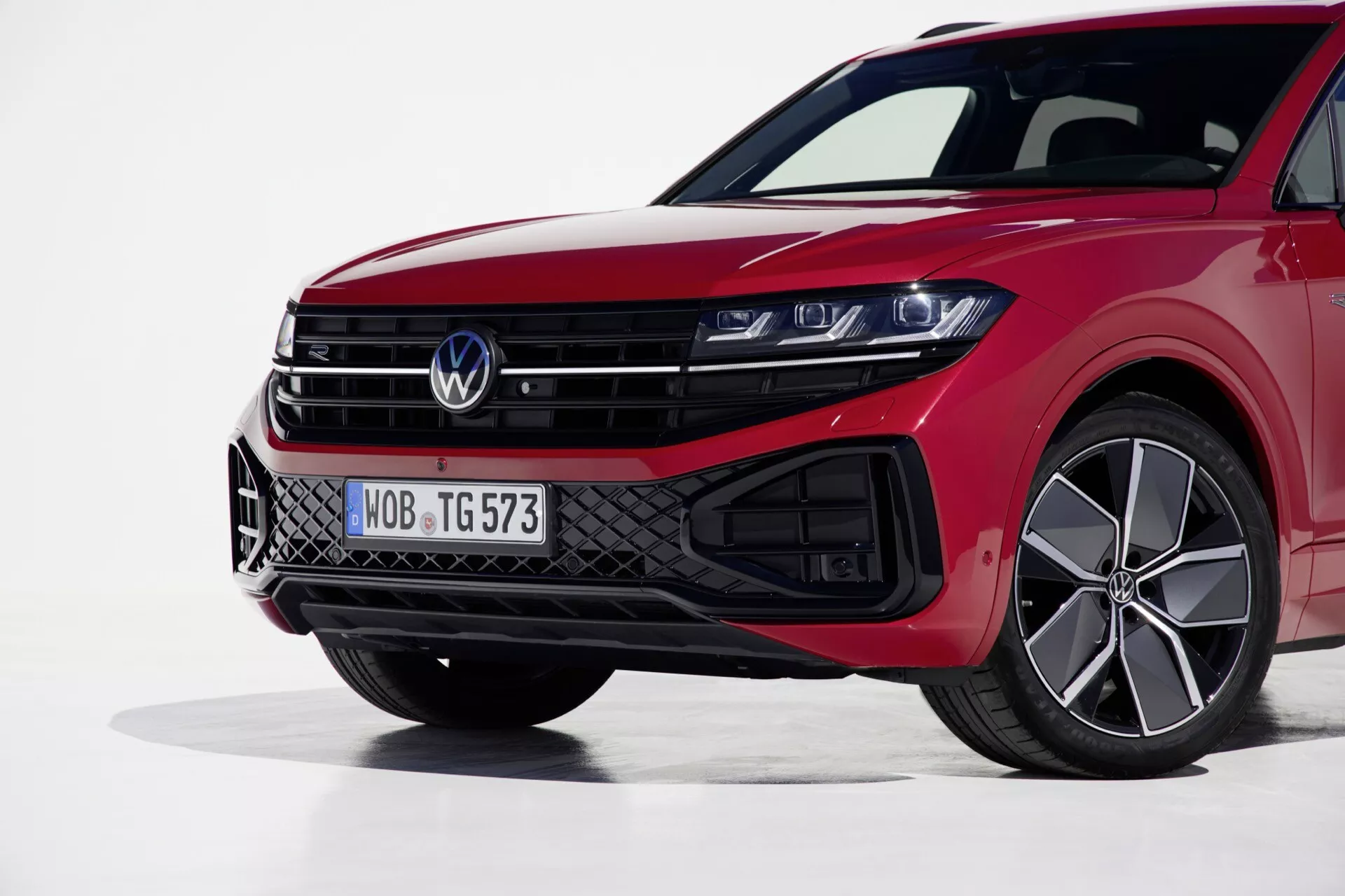 Lewy przedni widok Volkswagen Touareg 2023 podkreślający jego reflektory LED, sportową atrapę i wydajne czerwone wykończenie