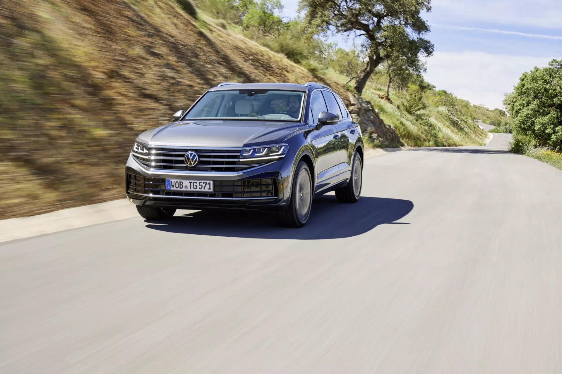 VW Touareg III facelift 2023 pokazany w dynamicznym ustawieniu drogowym, podkreślający reflektory LED, nowoczesną kratę, sportowe alufelgi i funkcje ADAS.