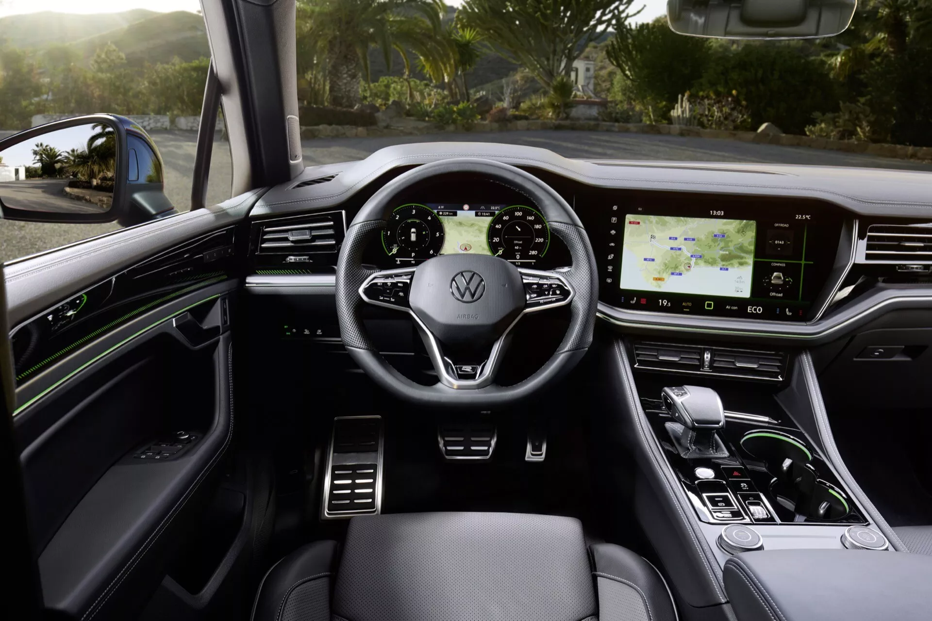 Widok wnętrza VW Touareg 2023 z miejsca kierowcy pokazujący Kierownicę z Logo Volkswagena, Nowoczesny Panel Instrumentów, Wysokorozdzielczy System Infotainmentu Dotykowego, Elementy Sterowania Klimatyzacją i Luksusowe Cechy Projektowe