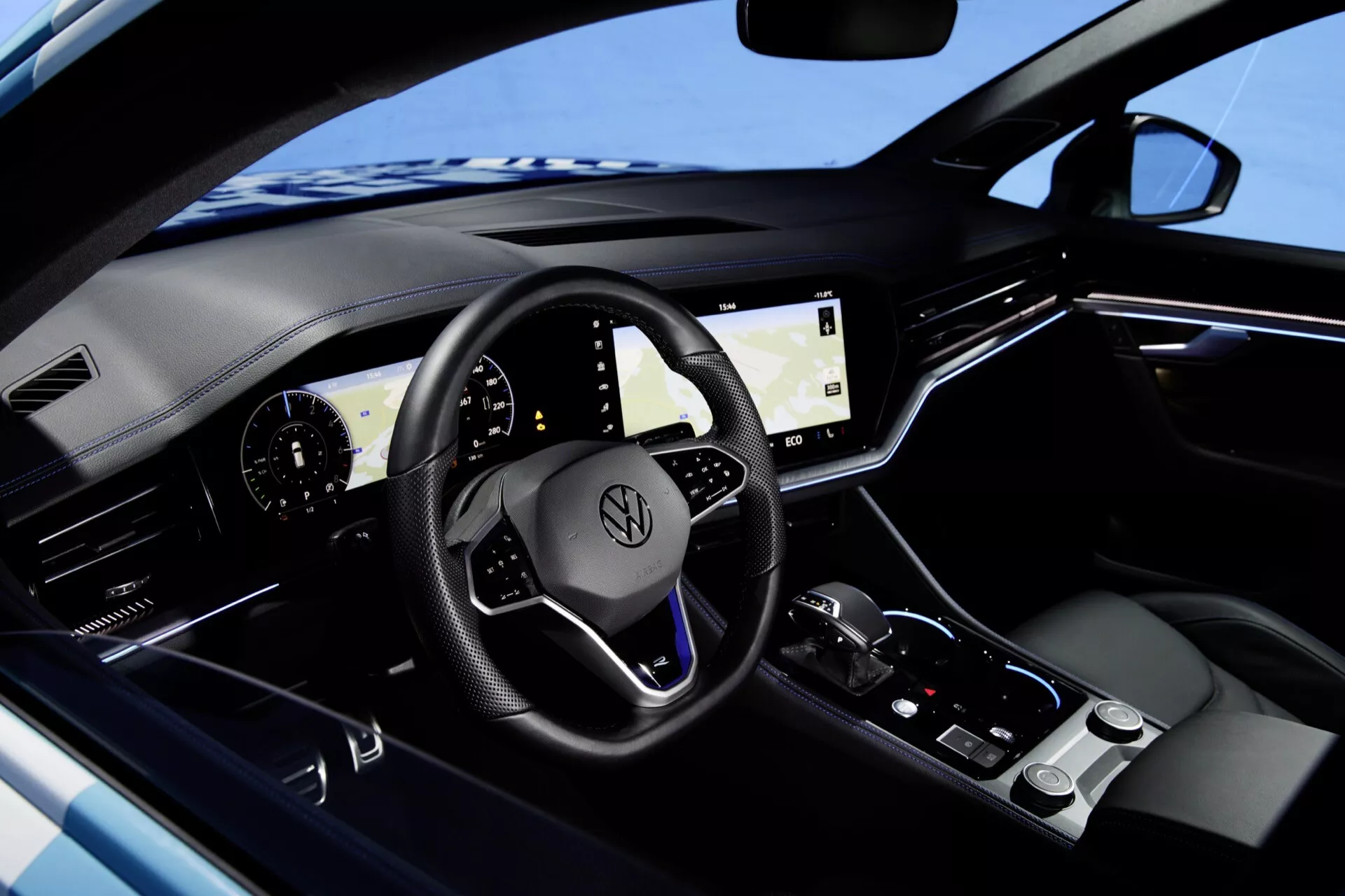 Wnętrze VW Touareg 2023 z zaawansowaną technologicznie deską rozdzielczą z cyfrowymi wyświetlaczami i sterowaniem dotykowym, luksusowymi ciemnymi wykończeniami z metalicznymi akcentami, i elegancką konsolą środkową